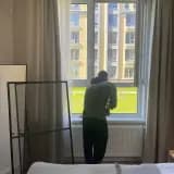 Мастер устанавливает москитную сетку в спальне