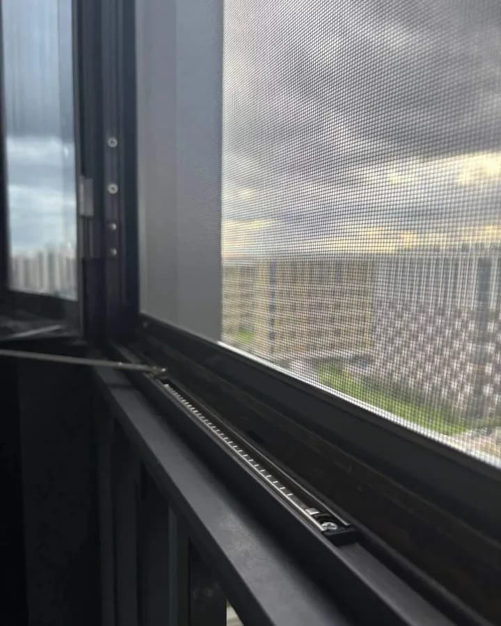 Ограничитель открывания на створке алюминиевого окна с москитной сеткой