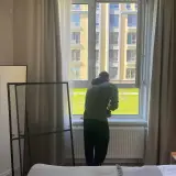 Мастер устанавливает москитную сетку в спальне